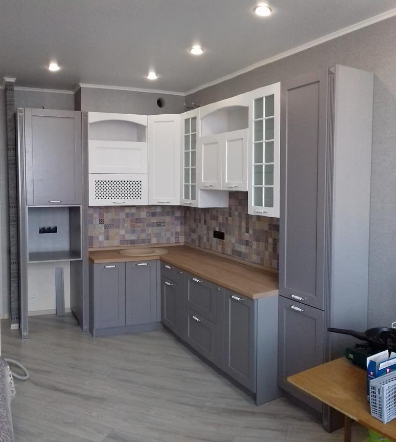 Фото угловая белая двухцветная матовая серая кухня с крашеными фасадами в классическом стиле с пластиковой столешницей