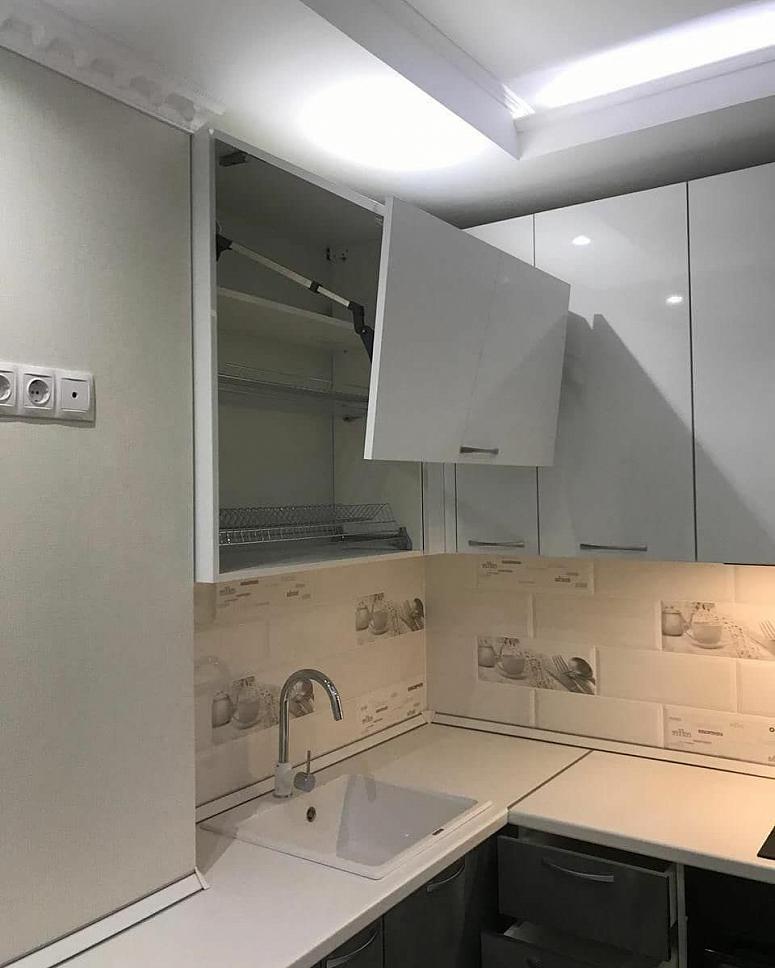 Фото угловая белая двухцветная глянцевая серая кухня с фасадами МДФ-ПВХ в стиле Хай-Тек с пластиковой столешницей