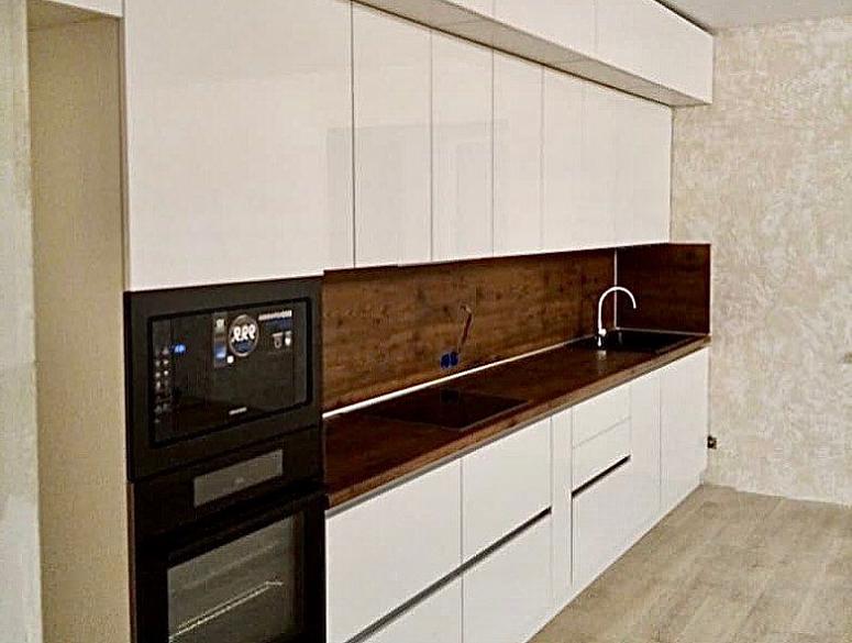 Фото прямая белая древесная кухня с пластиковыми фасадами в стиле Хай-Тек и в стиле Минимализм с пластиковой столешницей