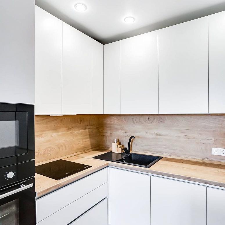 Фото угловая белая светлая матовая кухня с пластиковыми фасадами в стиле Хай-Тек и в стиле Минимализм с пластиковой столешницей