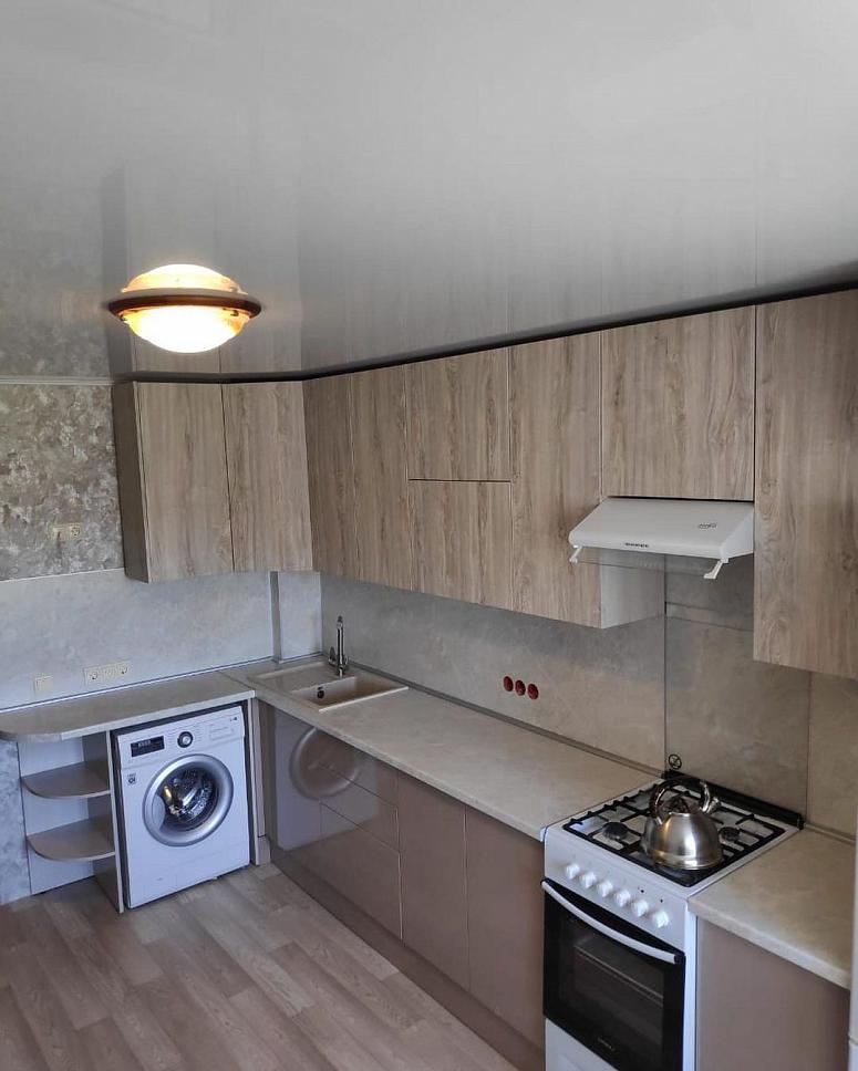 Фото угловая бежевая древесная двухцветная глянцевая матовая светлая кухня с фасадами МДФ-ПВХ в стиле Хай-Тек