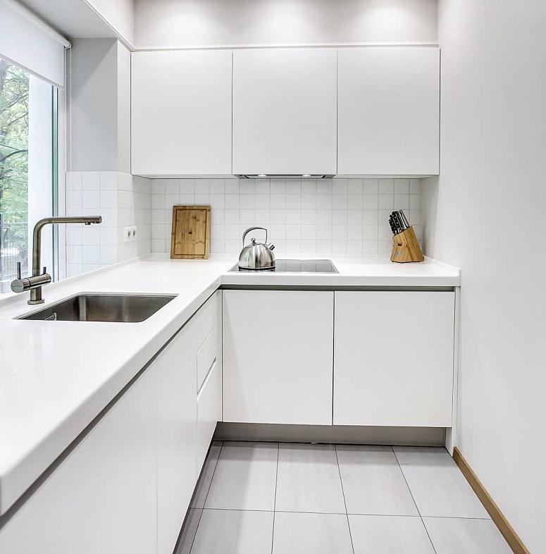 Фото угловая белая глянцевая светлая кухня с пластиковыми фасадами в стиле Хай-Тек и в стиле Минимализм c акриловой столешницей