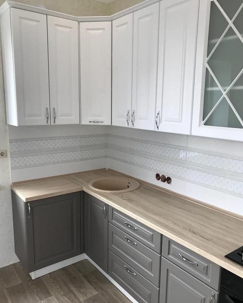 Фото угловая белая двухцветная матовая серая светлая кухня с крашеными фасадами в неоклассическом стиле с пластиковой столешницей