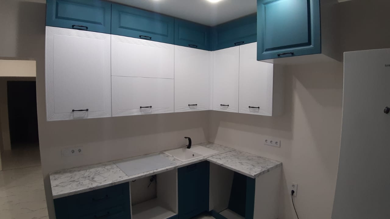 Белая угловая кухня с фасадами МДФ-ПВХ в неоклассическом стиле с пластиковой столешницей