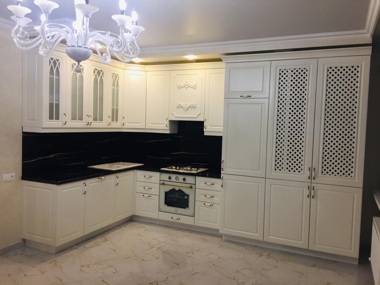 Фото угловая белая матовая кухня с крашеными фасадами в классическом стиле с пластиковой столешницей