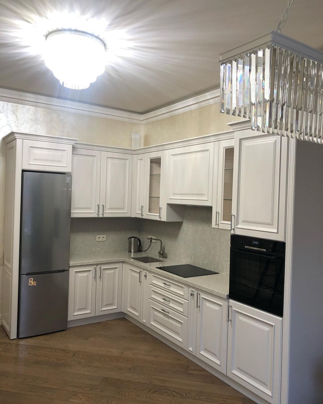 Белая угловая кухня с крашеными фасадами в классическом стиле с кварцевой столешницей