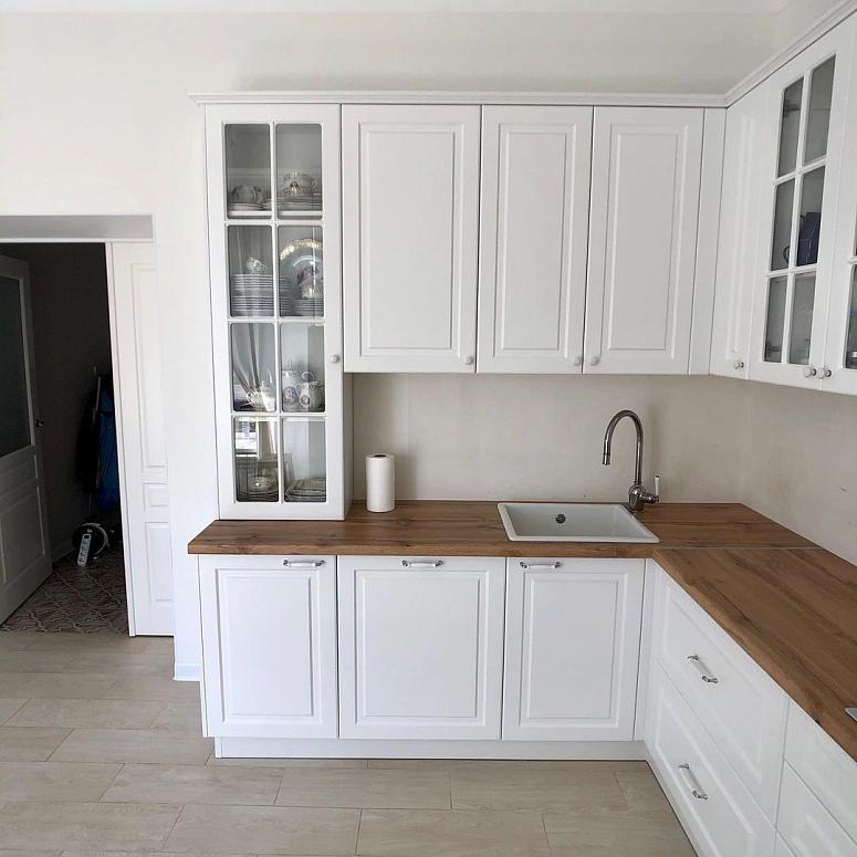Фото угловая белая матовая кухня с крашеными фасадами в неоклассическом стиле с пластиковой столешницей