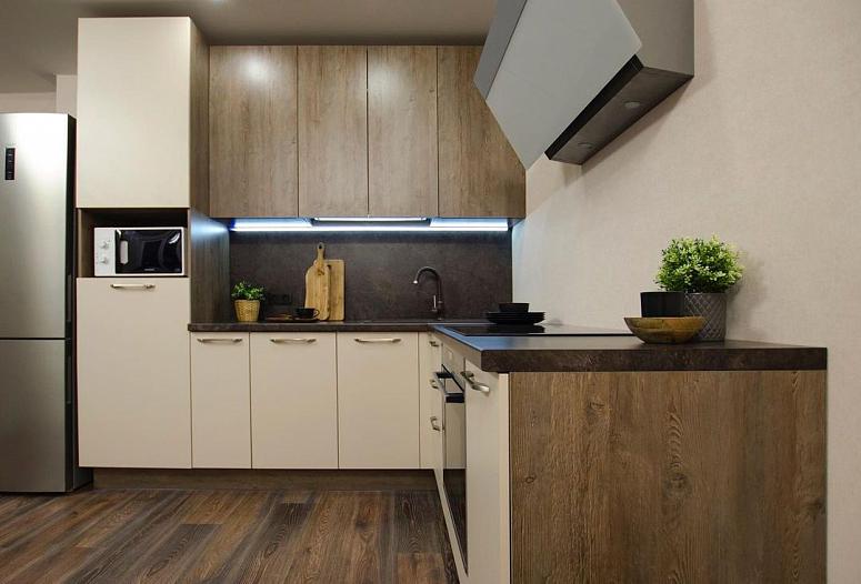 Фото угловая бежевая древесная двухцветная кухня с пластиковыми фасадами в стиле Хай-Тек и в стиле Лофт с пластиковой столешницей