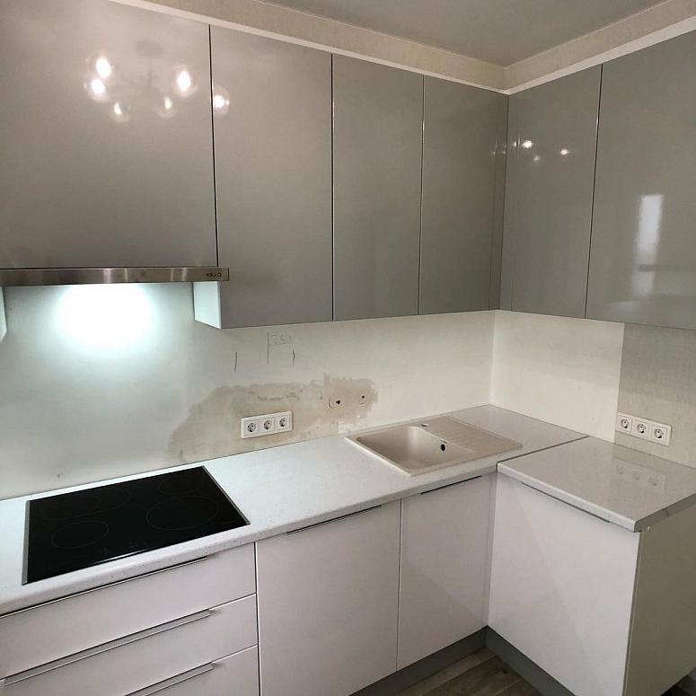 Фото угловая белая двухцветная серая кухня с фасадами МДФ-ПВХ в стиле Хай-Тек и в стиле Минимализм с пластиковой столешницей