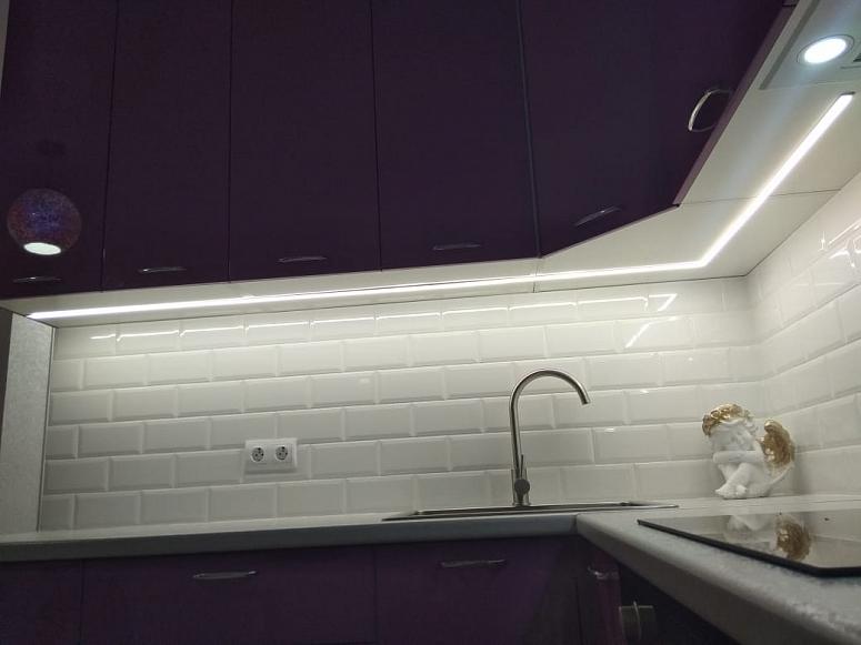 Фото угловая белая глянцевая яркая кухня с крашеными фасадами в стиле Хай-Тек с пластиковой столешницей