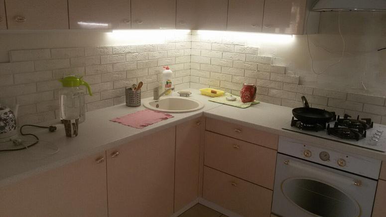 Фото угловая светлая глянцевая кухня с пластиковыми фасадами в стиле Хай-Тек с пластиковой столешницей