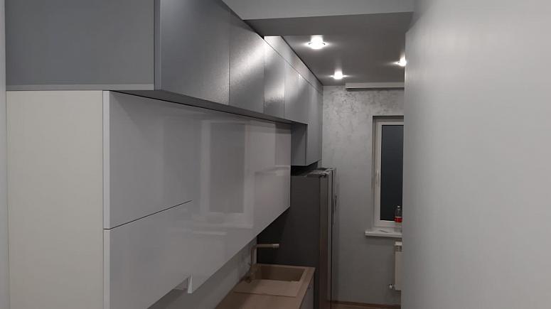 Фото прямая трехъярусная белая древесная двухцветная матовая серая светлая кухня с фасадами МДФ-ПВХ в стиле Хай-Тек с пластиковой столешницей