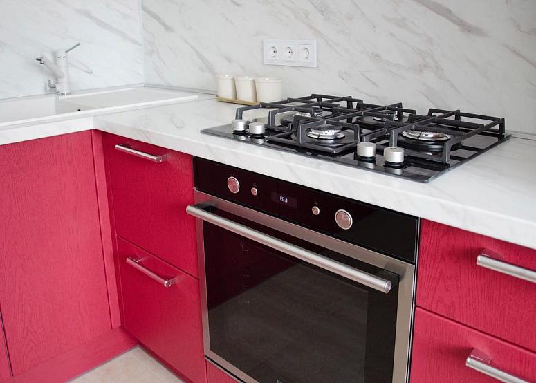 Фото угловая белая двухцветная красная матовая яркая кухня с фасадами МДФ-ПВХ в стиле Хай-Тек с пластиковой столешницей