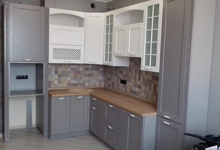 Фото угловая белая двухцветная матовая серая кухня с крашеными фасадами в классическом стиле с пластиковой столешницей