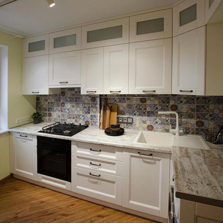 Фото угловая трехъярусная белая светлая древесная кухня с фасадами МДФ-ПВХ в неоклассическом стиле с пластиковой столешницей