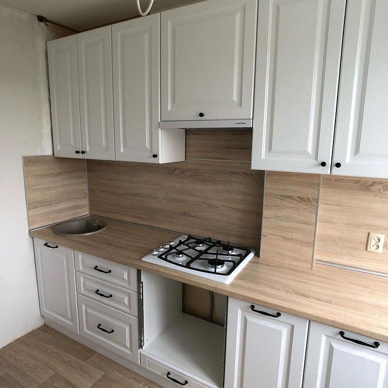 Фото прямая белая древесная матовая кухня с фасадами МДФ-ПВХ в неоклассическом стиле с пластиковой столешницей