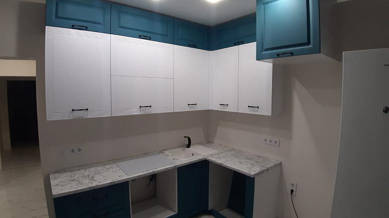 Фото угловая трехъярусная белая двухцветная матовая синяя яркая кухня с фасадами МДФ-ПВХ в неоклассическом стиле с пластиковой столешницей