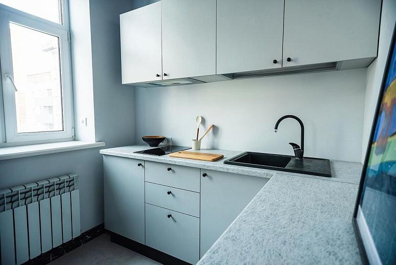 Фото угловая белая светлая матовая кухня с пластиковыми фасадами в стиле Хай-Тек с пластиковой столешницей