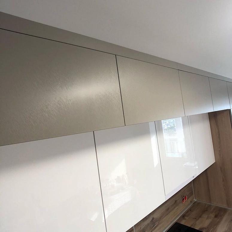 Фото прямая белая древесная двухцветная матовая серая темная кухня с пластиковыми фасадами с фасадами Fenix AGT в стиле Минимализм с пластиковой столешницей