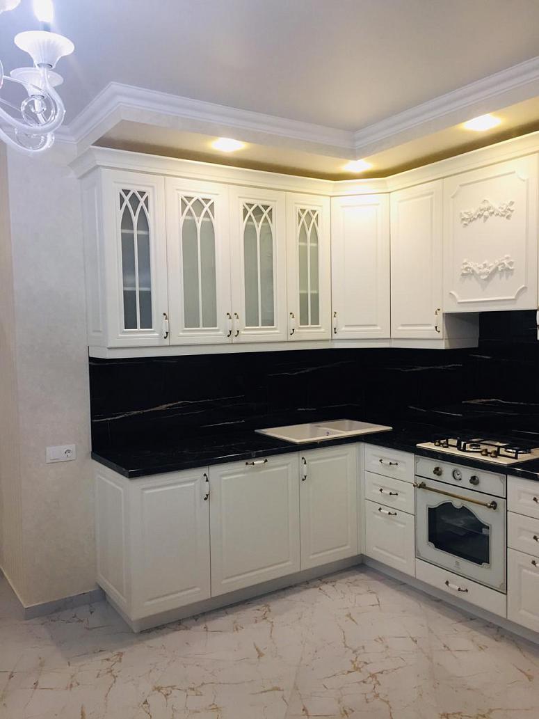 Фото угловая белая матовая кухня с крашеными фасадами в классическом стиле с пластиковой столешницей