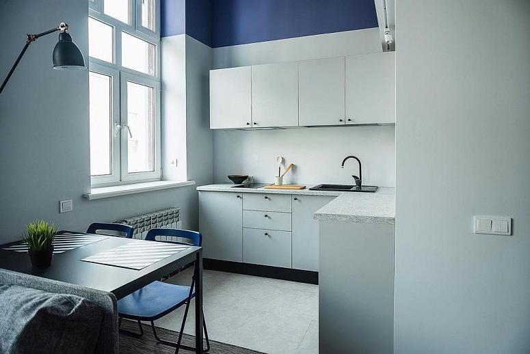 Фото угловая белая светлая матовая кухня с пластиковыми фасадами в стиле Хай-Тек с пластиковой столешницей