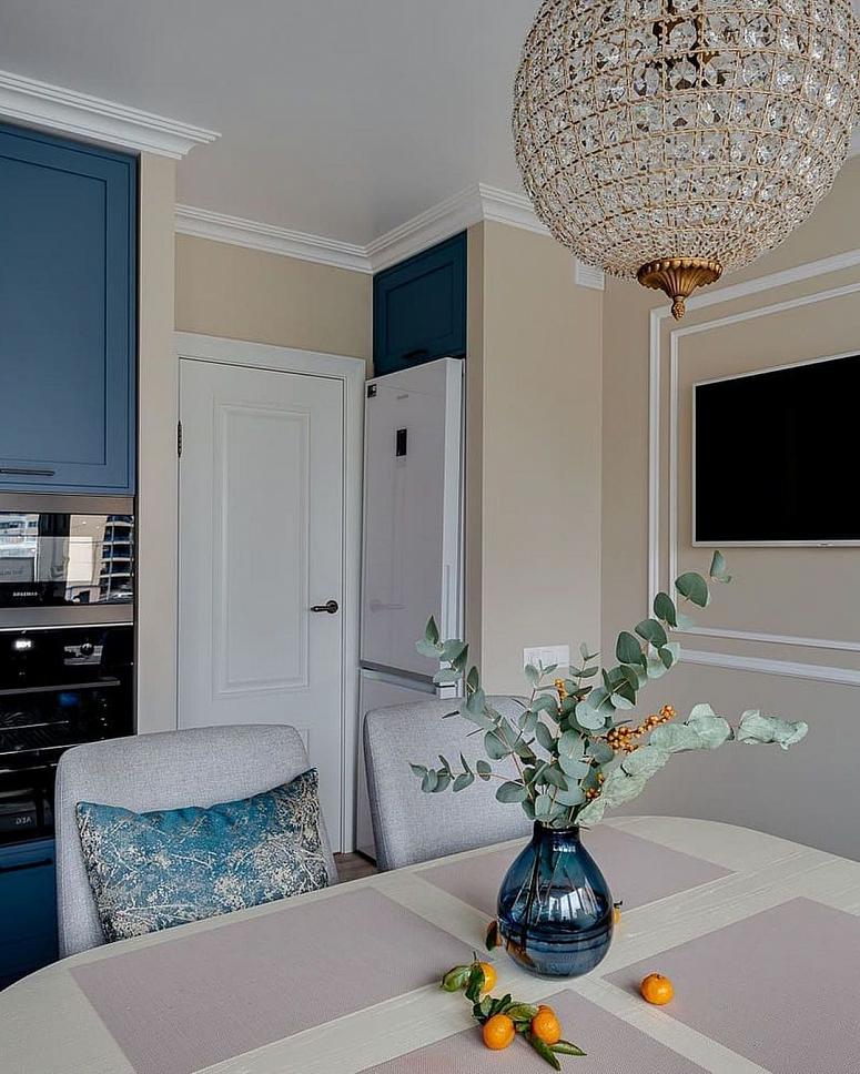 Фото угловая матовая синяя яркая кухня с крашеными фасадами в неоклассическом стиле c акриловой столешницей