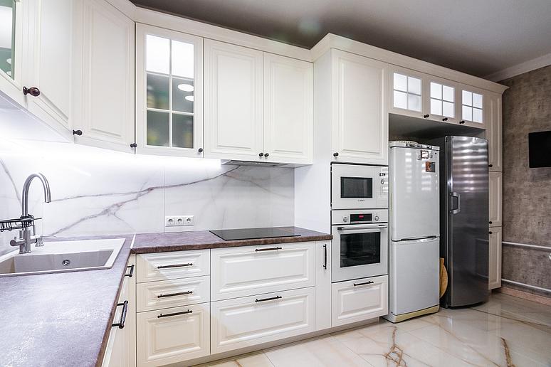Фото угловая светлая бежевая матовая кухня с крашеными фасадами в неоклассическом стиле с пластиковой столешницей