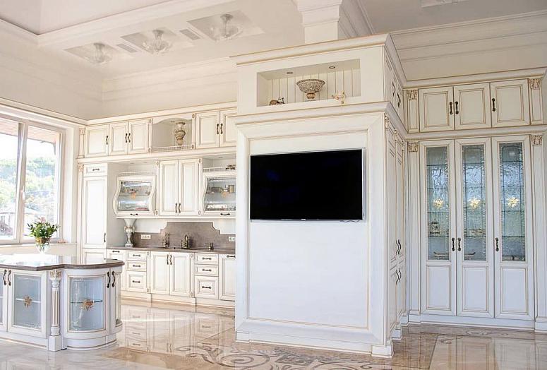 Фото угловая трехъярусная белая светлая под камень кухня из массива в классическом стиле со столешницей из натурального камня