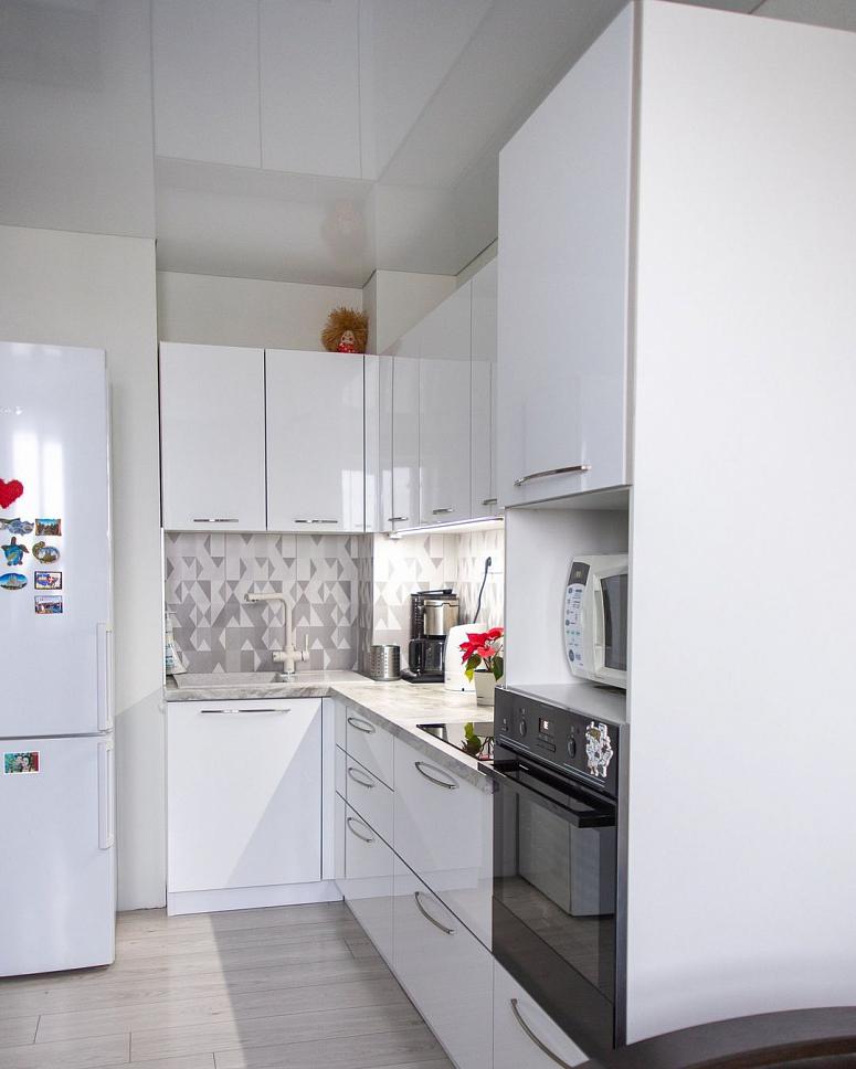 Фото угловая белая светлая глянцевая кухня с пластиковыми фасадами в стиле Хай-Тек и в стиле Минимализм с пластиковой столешницей