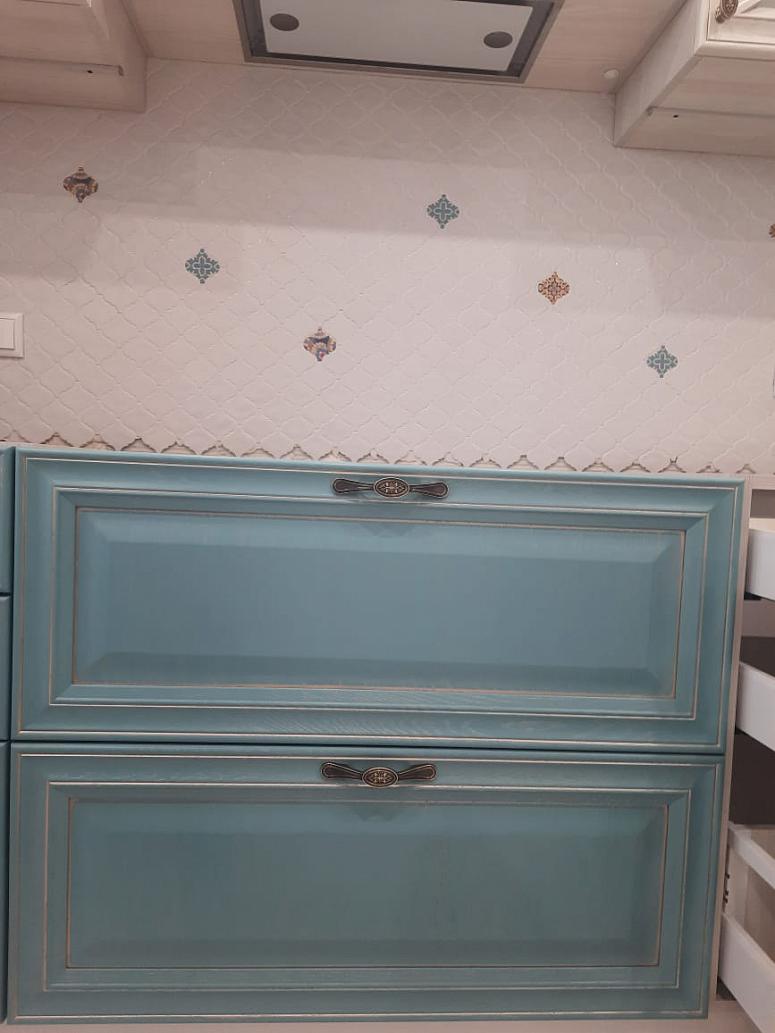 Фото угловая трехъярусная белая двухцветная матовая синяя светлая кухня из массива в неоклассическом стиле c акриловой столешницей