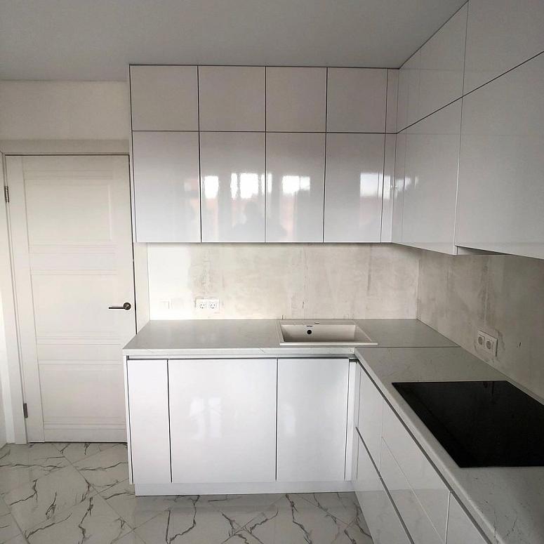 Фото угловая белая глянцевая кухня с фасадами МДФ-ПВХ в стиле Хай-Тек и в стиле Минимализм с пластиковой столешницей