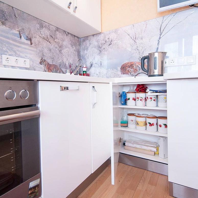 Фото угловая трехъярусная белая светлая глянцевая кухня с пластиковыми фасадами в стиле Хай-Тек c акриловой столешницей