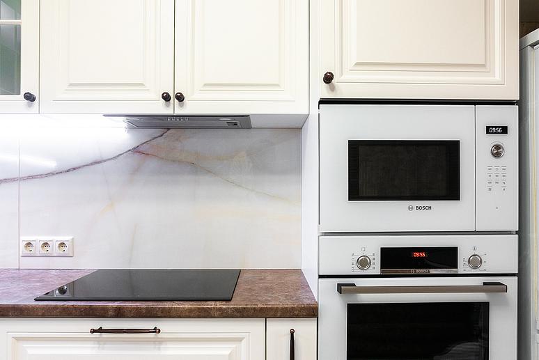 Фото угловая светлая бежевая матовая кухня с крашеными фасадами в неоклассическом стиле с пластиковой столешницей