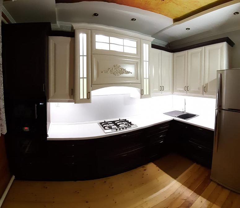 Фото угловая древесная двухцветная матовая светлая темная кухня из массива в классическом стиле с пластиковой столешницей