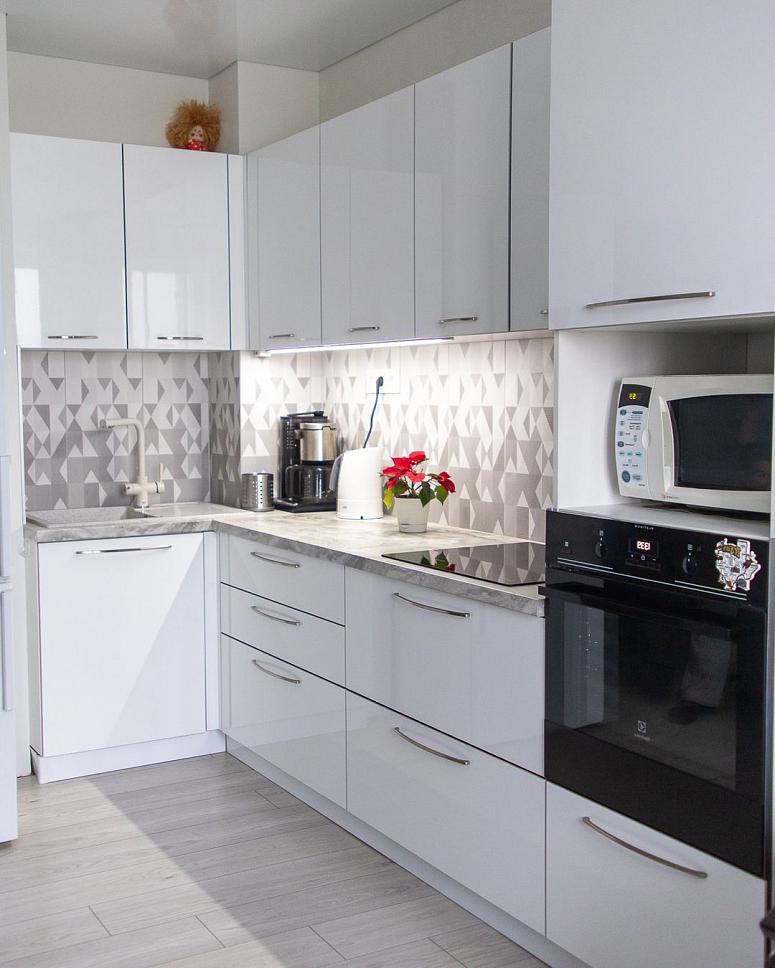 Фото угловая белая светлая глянцевая кухня с пластиковыми фасадами в стиле Хай-Тек и в стиле Минимализм с пластиковой столешницей