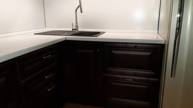 Фото угловая древесная двухцветная матовая светлая темная кухня из массива в классическом стиле с пластиковой столешницей