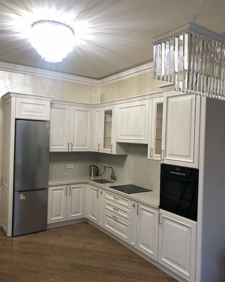 Фото угловая белая светлая матовая кухня с крашеными фасадами в классическом стиле с кварцевой столешницей