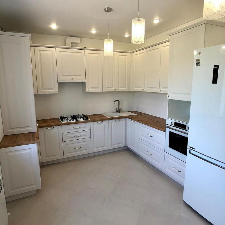 Фото п-образная белая светлая кухня с крашеными фасадами в классическом стиле с пластиковой столешницей
