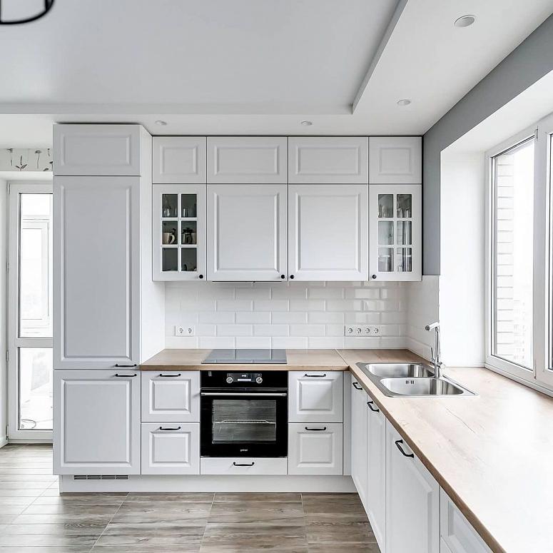 Фото угловая белая светлая древесная кухня с крашеными фасадами в неоклассическом стиле с пластиковой столешницей