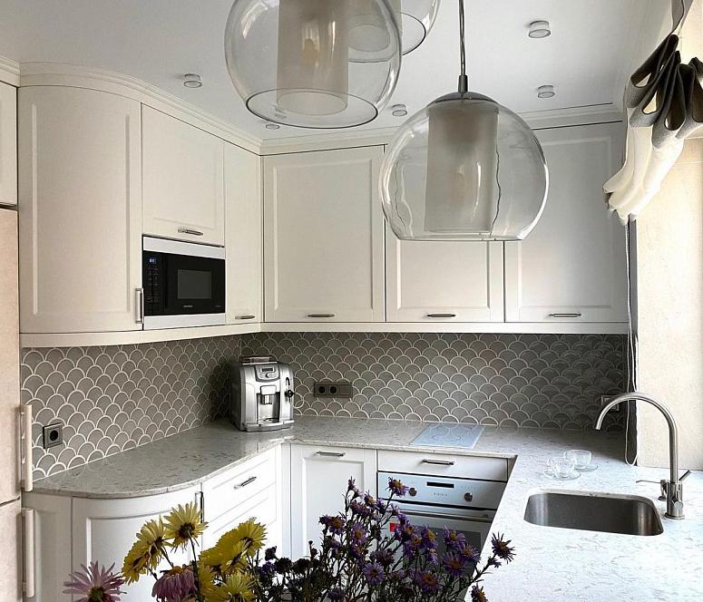 Фото п-образная светлая бежевая матовая кухня с крашеными фасадами в неоклассическом стиле c акриловой столешницей