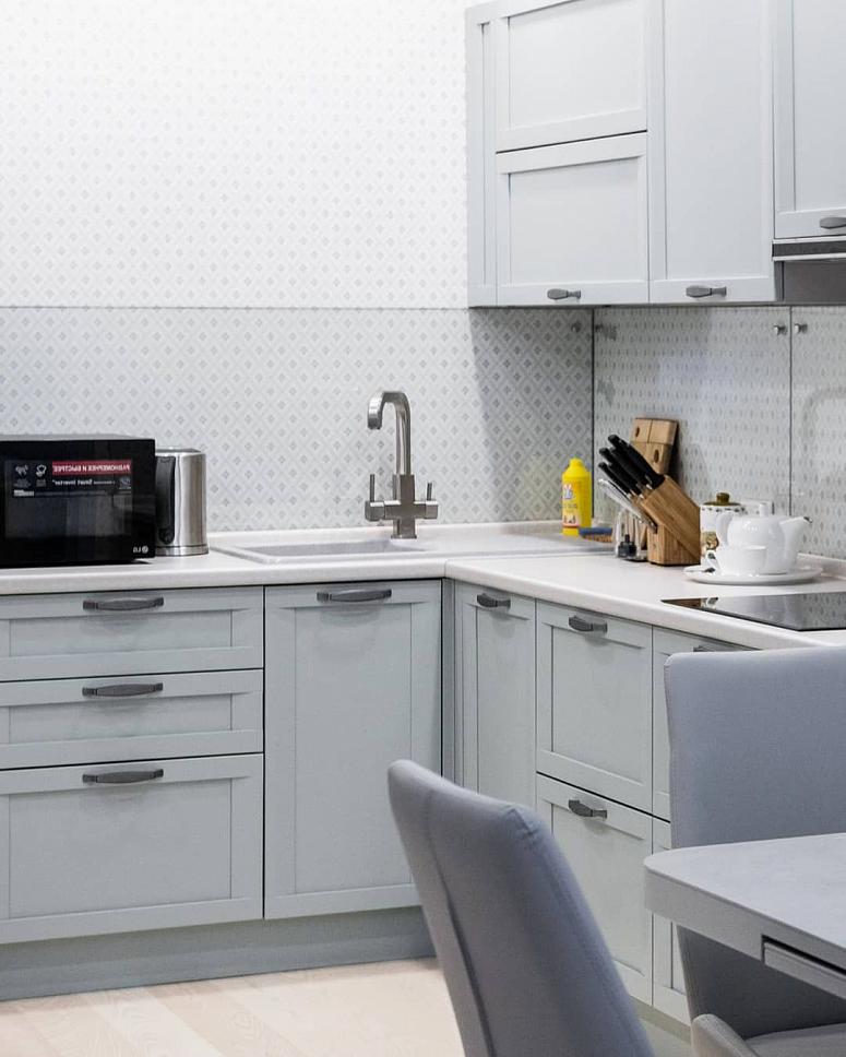 Фото угловая светлая серая кухня из массива в неоклассическом стиле с пластиковой столешницей