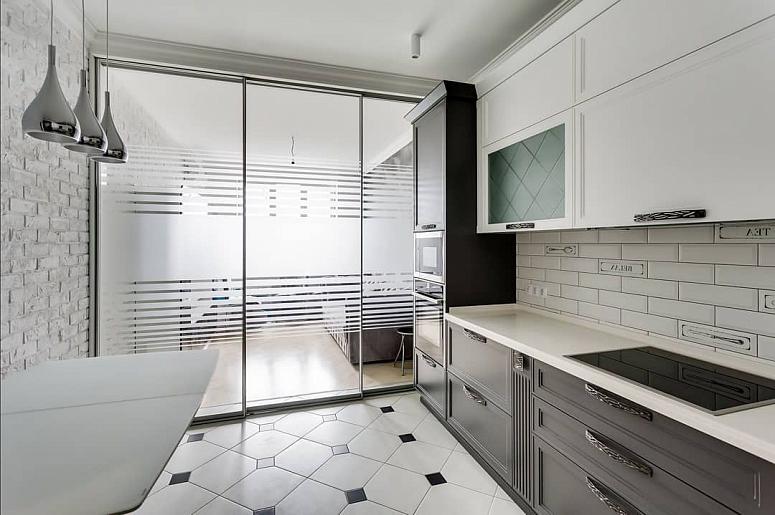 Фото угловая трехъярусная белая серая двухцветная кухня с крашеными фасадами в неоклассическом стиле со столешницей из натурального камня