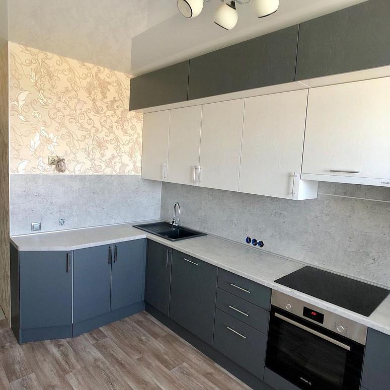 Фото угловая трехъярусная белая серая двухцветная кухня с фасадами МДФ-ПВХ в стиле Хай-Тек с пластиковой столешницей