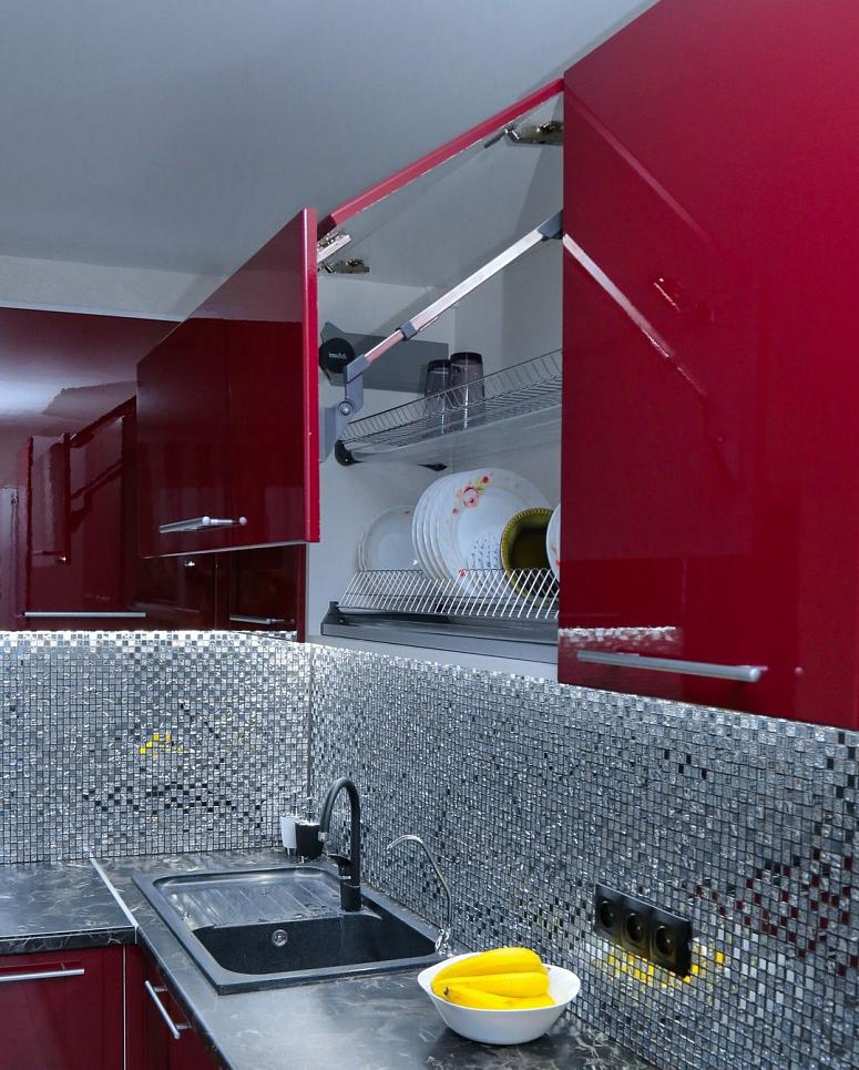 Фото угловая яркая красная глянцевая кухня с фасадами МДФ-ПВХ в стиле Хай-Тек с пластиковой столешницей
