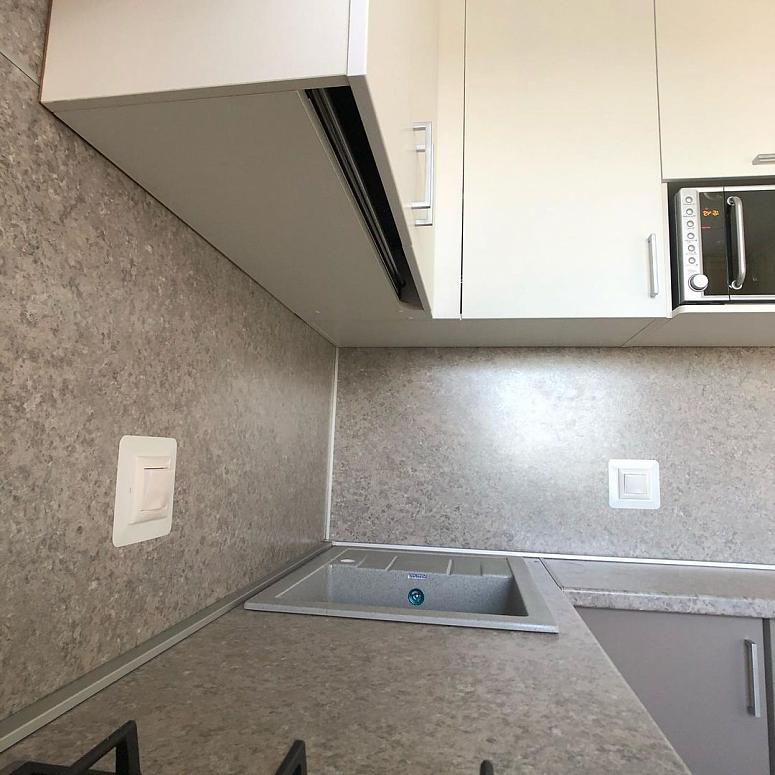 Фото угловая белая серая двухцветная кухня с фасадами МДФ-ПВХ в стиле Хай-Тек с пластиковой столешницей
