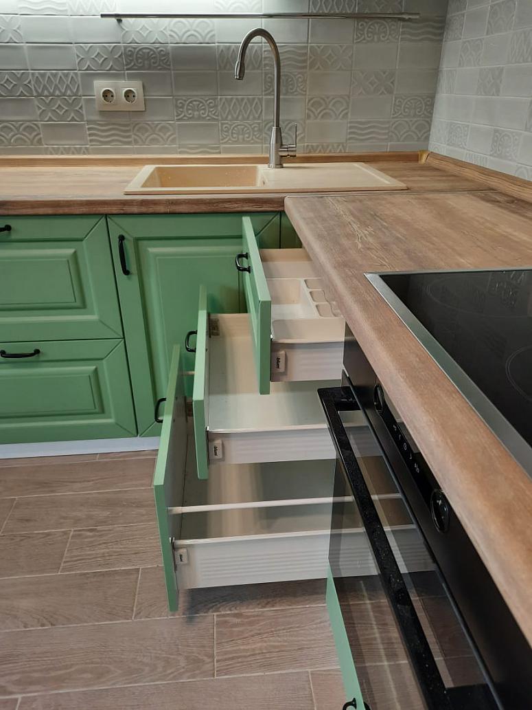 Фото угловая древесная двухцветная матовая яркая зеленая кухня с крашеными фасадами в классическом стиле с пластиковой столешницей